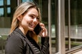 Portrait of a beautiful businesswoman smiling while talking on the phone outside of a building Royalty Free Stock Photo