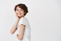 Portrait of beautiful candid woman with short hair, looking behind at empty space, staring right and smiling happy