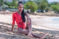 Portrait of Beautiful Caribbean Adult Teen in Barbados. Wearing Red Bikini and Sitting on a tropical beach. Caribbean Sea in Royalty Free Stock Photo