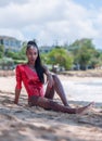 Portrait of Beautiful Caribbean Adult Teen in Barbados. Wearing Red Bikini and Sitting on a tropical beach. Caribbean Sea in Royalty Free Stock Photo