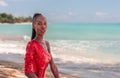 Portrait of Beautiful Caribbean Adult Teen in Barbados. Wearing Red Bikini and Sitting on a tropical beach. Caribbean Sea in Royalty Free Stock Photo