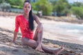 Portrait of Beautiful Caribbean Adult Teen in Barbados. Wearing Red Bikini and Sitting on a tropical beach. Caribbean Sea in Royalty Free Stock Photo