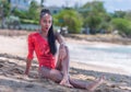 Portrait of Beautiful Caribbean Adult Teen in Barbados. Wearing Red Bikini and Sitting on a tropical beach. Caribbean Sea in Royalty Free Stock Photo