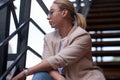 Portrait of sucessful woman on steel stairs at back yard.