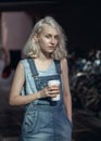 Portrait of beautiful Caucasian teenage young blonde alternative model girl woman in blue tshirt, jeans romper Royalty Free Stock Photo