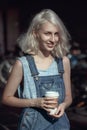 Portrait of beautiful Caucasian teenage young blonde alternative model girl woman in blue tshirt, jeans romper looking in camera Royalty Free Stock Photo