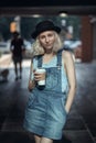 Portrait of beautiful Caucasian teenage young blonde alternative model girl woman in blue tshirt, jeans romper looking in camera Royalty Free Stock Photo