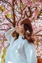 portrait of beautiful caucasian woman with blooming sakura cherry trees Royalty Free Stock Photo