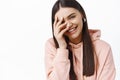 Portrait of beautiful caucasian woman laughing and covering face with hand, chuckle over something funny, express happy