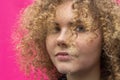 Portrait of beautiful cheerful curly girl on bright pink background. Blonde caucasian woman looking at camera Royalty Free Stock Photo