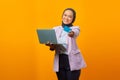 Portrait of beautiful and cheerful young woman standing holding laptop and showing credit card Royalty Free Stock Photo