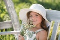 Portrait of beautiful child girl in the summer blossoming garden. Happy kid on the meadow with white flowers. Warm