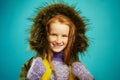 Portrait of beautiful children girl cute smiling, wears autumn warm jacket with fur hood, expresses sincerity, has red