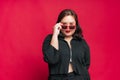 Portrait beautiful confidence Asian woman plus size wearing sunglasses posing in black dress fashion on isolate studio red Royalty Free Stock Photo