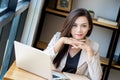 Portrait of beautiful and confident Asian business woman in working age using computer laptop technology for manage job work Royalty Free Stock Photo