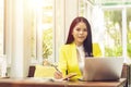 Portrait of beautiful and confident Asian business woman in working with notebook laptop and book manage job work at workplace. Royalty Free Stock Photo