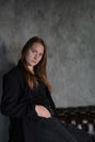 portrait of beautiful confident brunette woman in black in grey dark room. business woman. feminine. millennial people