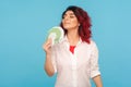 Portrait of beautiful confident business woman with fancy red hair holding money with expression of pleasure