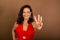 Portrait of beautiful confident cheerful woman doing number three with her fingers. Motivating person