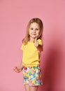 Portrait of a beautiful and confident girl child in summer clothes showing thumbs up isolated one pink Royalty Free Stock Photo