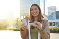 Portrait of beautiful confident girl typing number of credit card on smartphone makes purchase online or checks bank account