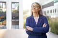 Portrait of a beautiful confident mature business woman in eyeglasses and classic wear keeping arms crossed and looking Royalty Free Stock Photo