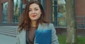 Portrait of beautiful and confident young woman in formal suit standing near modern office building, looking at camera Royalty Free Stock Photo