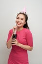 Portrait of beautiful crazy smiling woman on white drinking soda from bottle with straw