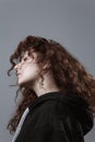 Portrait of a beautiful curly girl on a gray background