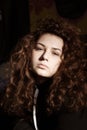 Portrait of a beautiful curly girl on a gray background