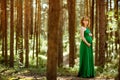 Portrait of a beautiful curly haired pregnant girl in the green Royalty Free Stock Photo