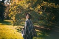 Portrait of a beautiful curly young woman in an autumn park in a hat and a plaid scarf walking enjoying nature Royalty Free Stock Photo