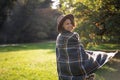 Portrait of a beautiful curly young woman in an autumn park in a hat and a plaid scarf walking enjoying nature Royalty Free Stock Photo