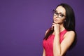 Portrait of beautiful and cute brunette model girl with professional makeup in black glasses and in red dress holds her hand near Royalty Free Stock Photo