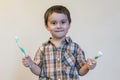 portrait of a beautiful cute caucasian blond boy with a toothbrush. Little boy brushing teeth and smiling while taking care of