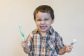 Portrait of a beautiful cute caucasian blond boy with a toothbrush. Little boy brushing teeth and smiling while taking care of