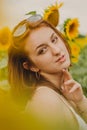 Portrait of a beautiful, cute, sexy red-haired girl in a white dress and glasses. Walks in the sunflowers. Emotion of pleasure, Royalty Free Stock Photo