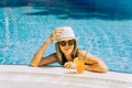 Portrait of beautiful cute smiling young woman lady girl in a bikini, hat, and sunglasses holding tropical lemonade Royalty Free Stock Photo