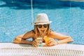 Portrait of beautiful cute smiling young woman lady girl in a bikini, hat, and sunglasses holding tropical lemonade Royalty Free Stock Photo