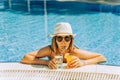 Portrait of beautiful cute smiling young woman lady girl in a bikini, hat, and sunglasses holding tropical lemonade Royalty Free Stock Photo