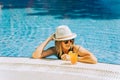 Portrait of beautiful cute smiling young woman lady girl in a bikini, hat, and sunglasses holding tropical lemonade Royalty Free Stock Photo