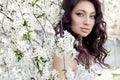 Portrait beautiful cute sweet girl bride with gentle eye make-up full lips in white light dress walks in lush gard