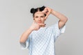 Portrait of beautiful dark-haired teen girl making frame with hands and fingers with happy face, standing in trendy t shirt over Royalty Free Stock Photo