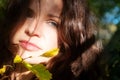 Portrait of a beautiful dark-haired young sexy seductive enigmatic woman in the forest in sunlight with green leaves Royalty Free Stock Photo