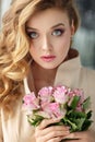 Portrait of a beautiful delicate sensual blonde girl with roses, standing outside the window. Close-up Royalty Free Stock Photo
