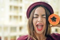 Portrait of beautiful elegant female wearing red felt hat holding half of papaya fruit next to her face Royalty Free Stock Photo