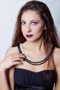 Portrait of a beautiful elegant girls brunette long hair with a pearl necklace on the neck with a bright festive makeup