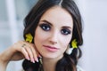 Portrait of beautiful european woman in yellow earings in white apartment, pretty young woman with dark hair in light Royalty Free Stock Photo