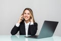 Portrait of beautiful executive business woman making call while sitting at her workplace in front of laptop and working on new Royalty Free Stock Photo