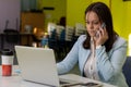 Portrait of beautiful executive professional woman making call while sitting at her workplace in front of laptop Royalty Free Stock Photo